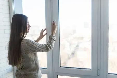 mujer abriendo la ventana