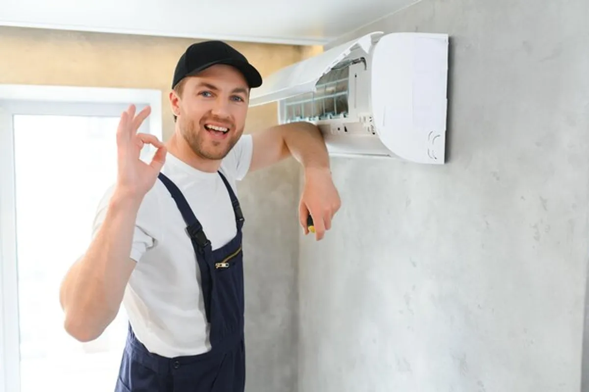 Técnico dando el visto bueno a un aire acondicionado recién instalado