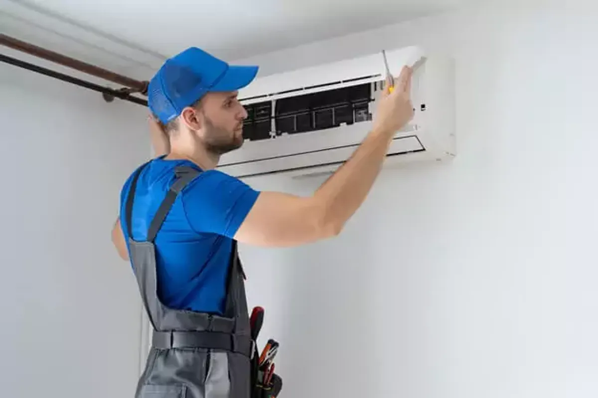 Técnico revisando una unidad de aire acondicionado en una vivienda de Madrid