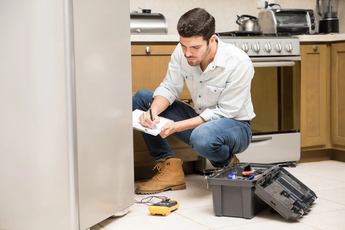 Técnico revisando un electrodoméstico averiado en la cocina de un cliente en Madrid